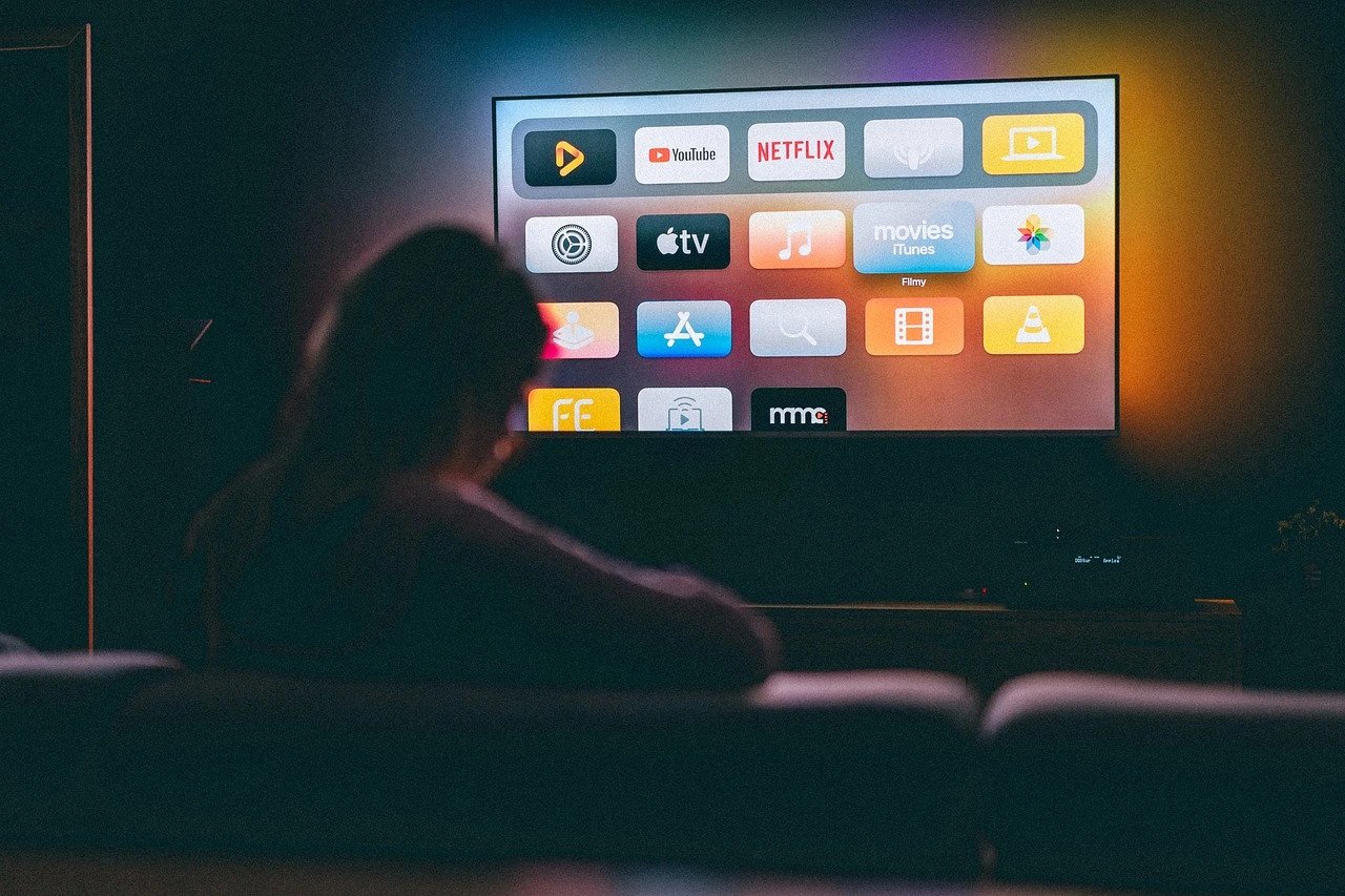 Man is Lying on a Sofa and Watching Movies on Apple TV