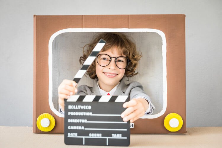 Image of girl holding film flap with smiling face